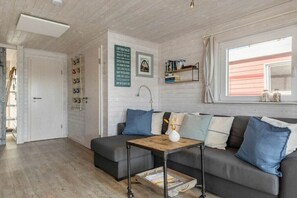 A cozy living room with a grey sofa, a wooden coffee table, and a white vase.