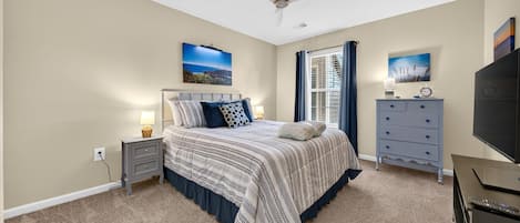A bedroom with a bed, nightstand, dresser, and ceiling fan.