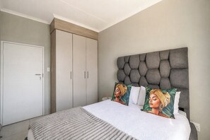 Une chambre à coucher avec un lit, une armoire et une tête de lit.
