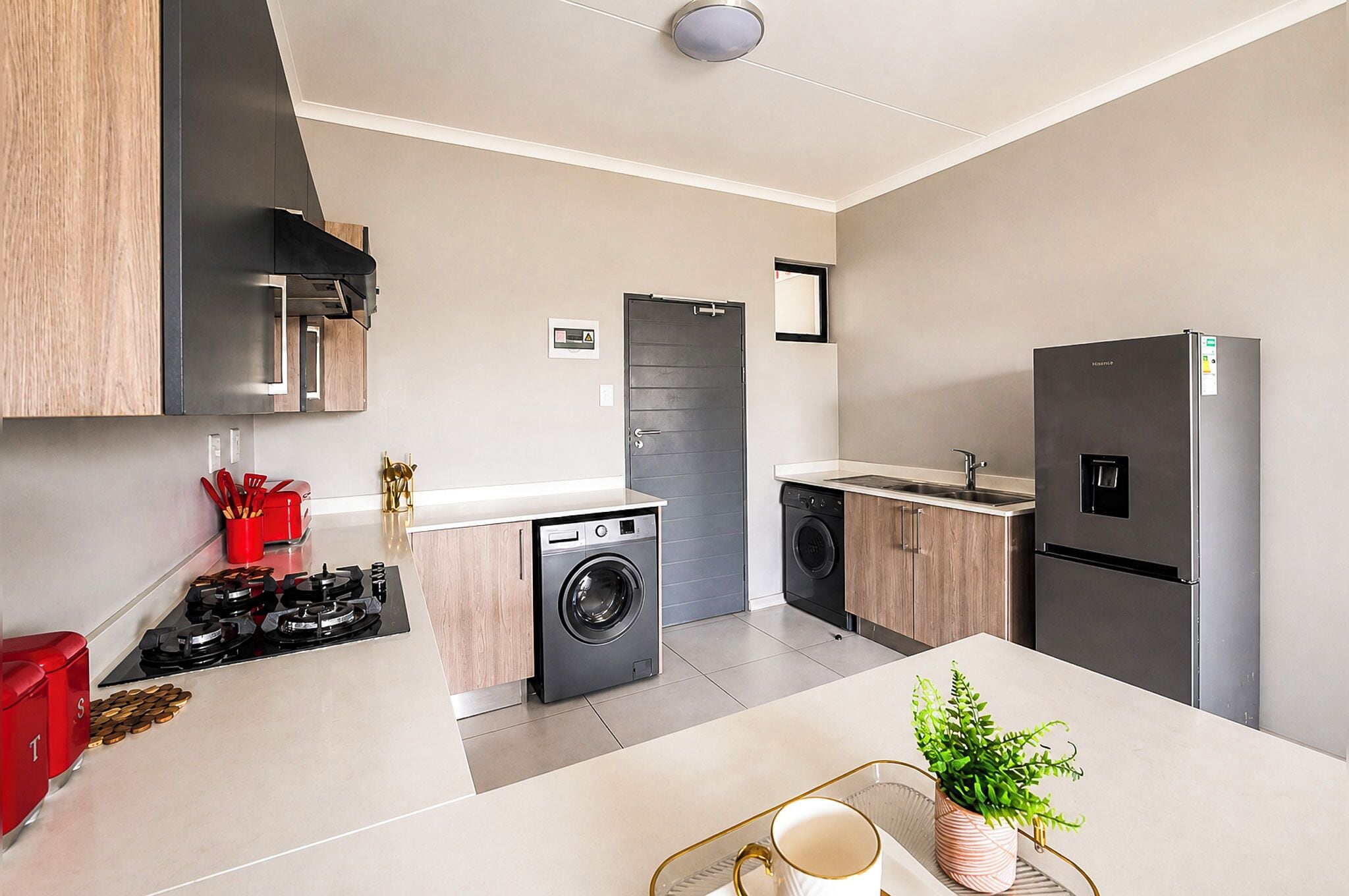 Una cocina moderna con lavadora, refrigerador y fregadero.