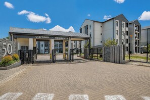 A building with a sign indicating separate entrances for visitors and residents. - Luxury 2 bedroom, 2 bathroom apartment in Carlswald with swimming pool. (Midrand)