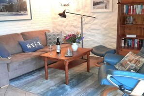 Un salon avec un canapé, une table basse et une bibliothèque.