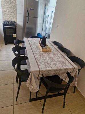 A dining area with a table set for four, a coffee maker, and a kettle on the table. - Vrbo Property (Franca)