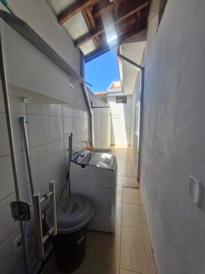 A compact bathroom with a toilet, a small sink, and a shower area. - Vrbo Property (Franca)