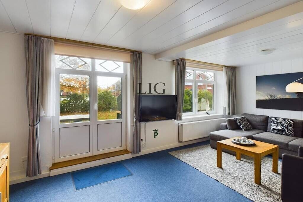A living room with a television, sofa, and coffee table.