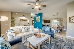 A living room with a sofa, armchair, coffee table, and a ceiling fan. - Holiday home with 1 bedroom (Cape Coral)