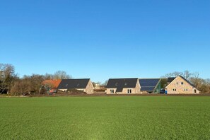 Een woonwijk met huizen en een groot, groen veld.