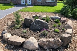 A landscaped garden area with large rocks and small plants. - House by the farm garden, Michel holiday farm (Fehmarn)