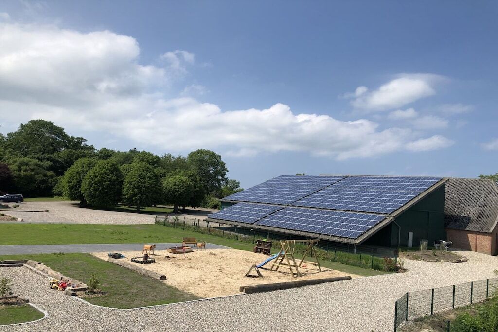 Ein Gebäude mit einem geneigten Dach und einer Solaranlage.