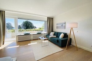 Un salon moderne avec un canapé, une table basse et un lampadaire.