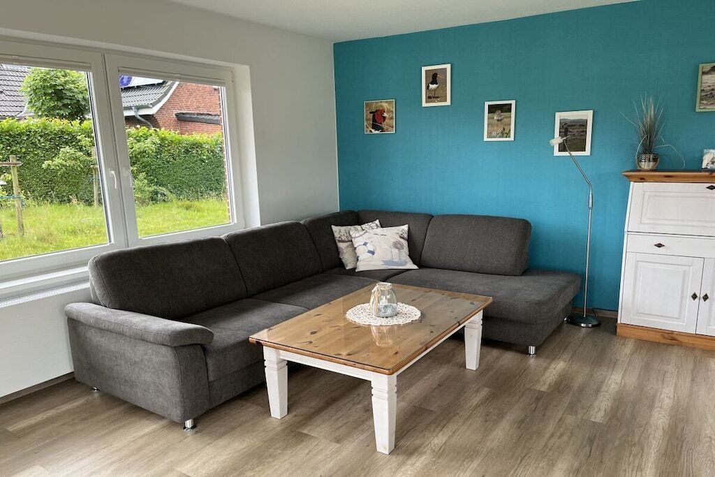 A living room with a grey sofa, a wooden coffee table, and a white cabinet.