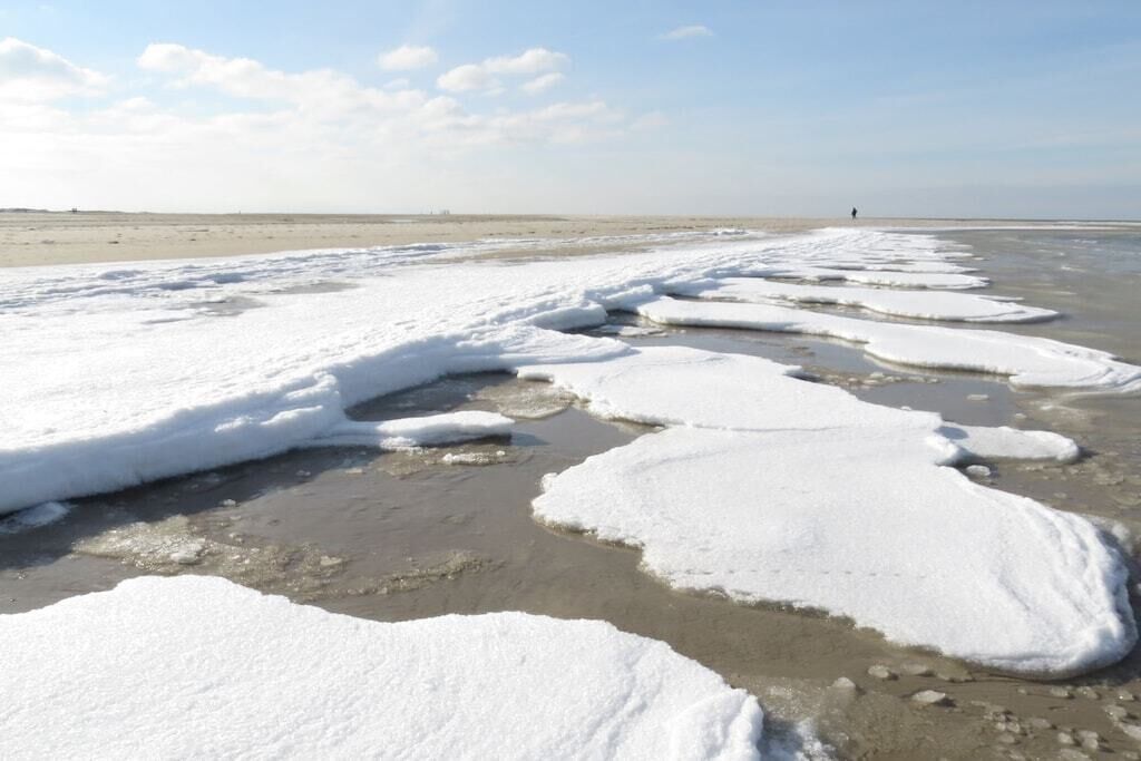 A frozen landscape with snow-covered ice formations and a distant horizon.