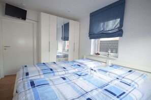 Ein Schlafzimmer mit Bett, Kleiderschrank und einem Fenster mit Blick.