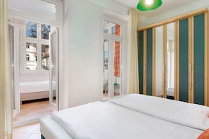 A hotel room with a bed, a sliding door, and a view of the outside. - Havana at Villa Malepartus (Binz)
