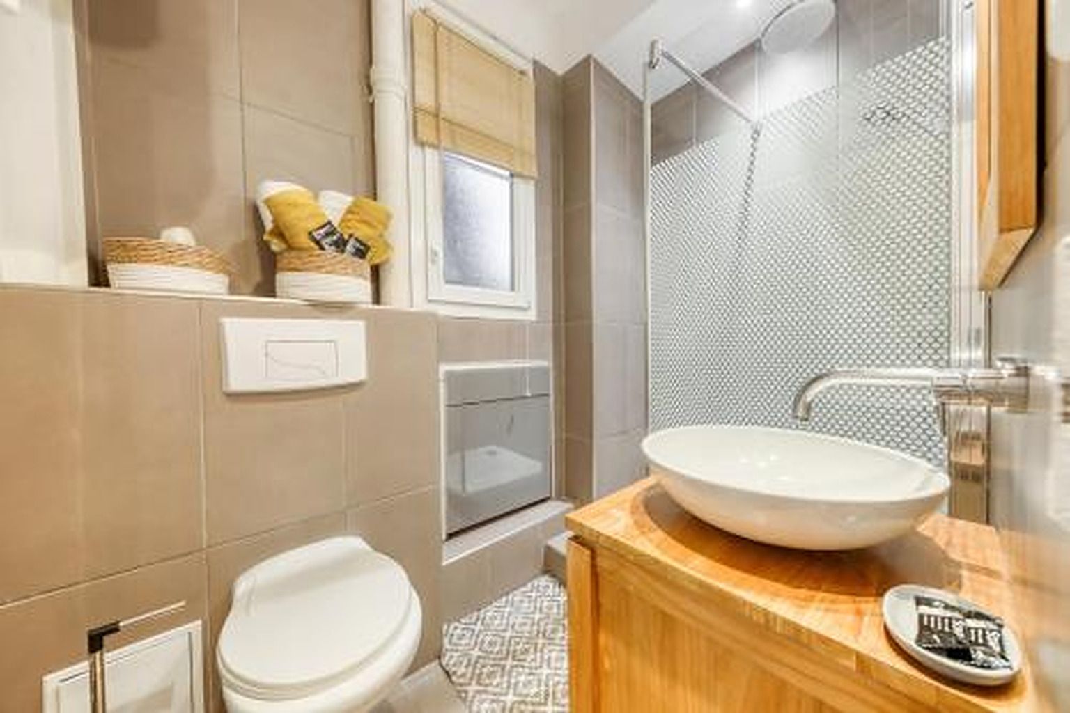 Een moderne badkamer met een ruime wastafel, toilet en douche.