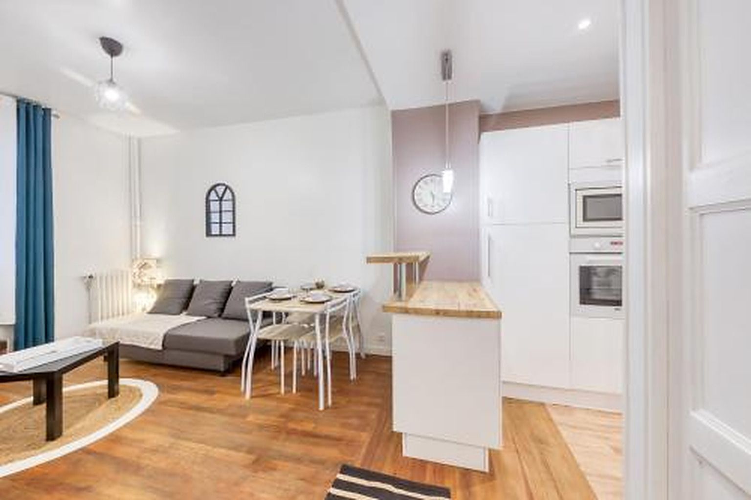 Een knus woongedeelte met een bank, eettafel en kitchenette.