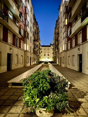 A courtyard with a central water feature, surrounded by multi-story buildings with balconies.