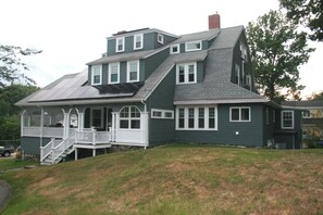 A two-story house with a porch and a staircase leading to the entrance. - Large 14bed Family Retreat a Stroll to York Harbor Beach and Venues (York)