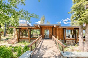 A wooden bridge leading to a building with large windows and a stone facade. - Site Line Ski-In/Ski-Out at Northstar by Tahoe Getaways - Pet-Friendly 4BR w Hot Tub & HOA (Truckee)