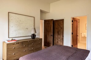 A bedroom with a bed, a dresser, a lamp, and a large abstract painting on the wall. - Site Line Ski-In/Ski-Out at Northstar by Tahoe Getaways - Pet-Friendly 4BR w Hot Tub & HOA (Truckee)