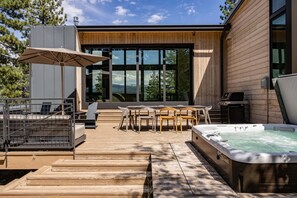 A modern outdoor patio with a hot tub, wooden deck, and outdoor furniture. - Site Line Ski-In/Ski-Out at Northstar by Tahoe Getaways - Pet-Friendly 4BR w Hot Tub & HOA (Truckee)