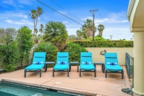 A poolside area with four blue lounge chairs and a small table. - Pet Friendly Desert Escape with Private Pool, Spa & Mountain View City id 069584 (Palm Springs)