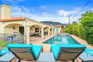 A poolside area with lounge chairs, a patio with outdoor furniture, and a mountain view in the background. - Pet Friendly Desert Escape with Private Pool, Spa & Mountain View City id 069584 (Palm Springs)