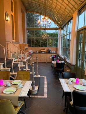 Un espace de restauration intérieur avec des tables, des chaises et un escalier.