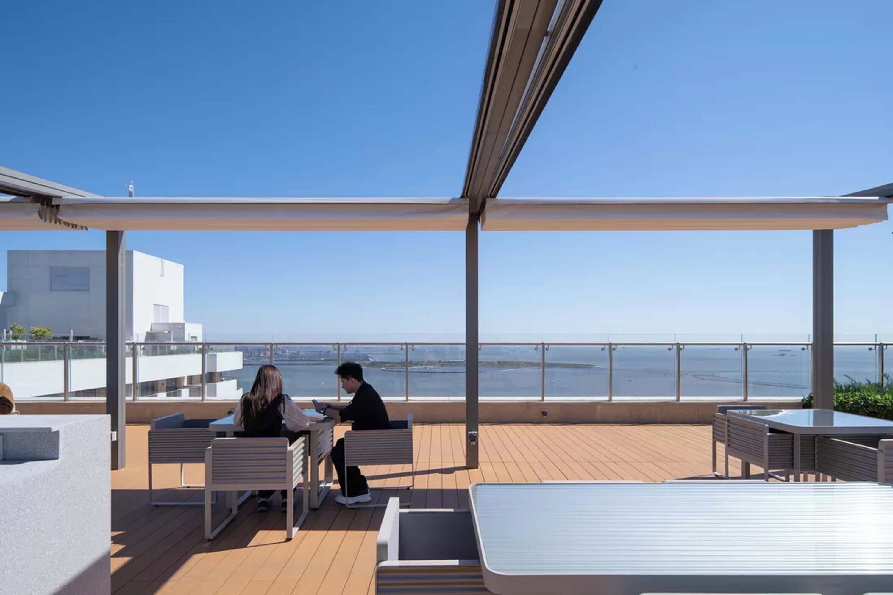 Una terraza al aire libre con asientos y vistas al mar.