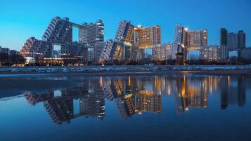 Un horizonte urbano con arquitectura moderna reflejado en aguas tranquilas.