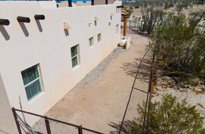 A building with multiple windows, a paved area, and a fenced perimeter. - Cozy Vicky's Villa with Pool Access (San Felipe)