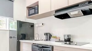 A modern kitchen with a dishwasher, microwave, and stainless steel appliances.