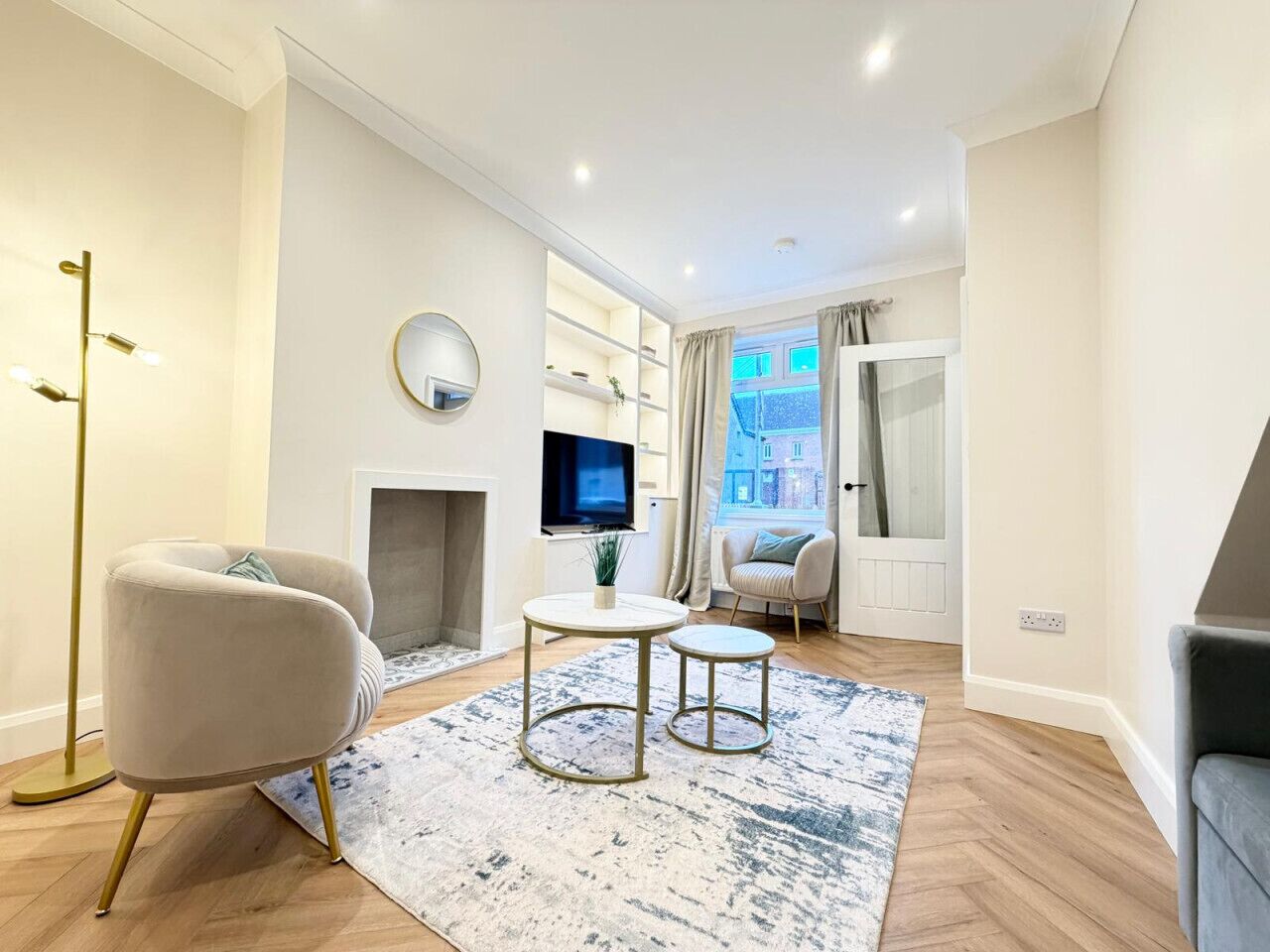 Un salon moderne avec un canapé, une table basse et un téléviseur.