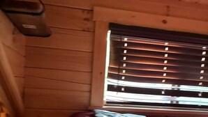 A room with wooden walls and a window with blinds.