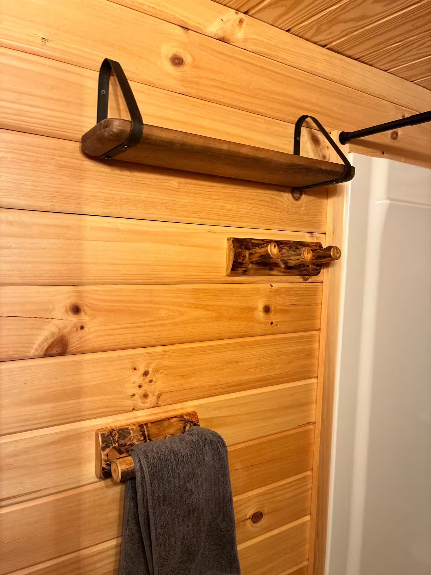 A wooden wall with a towel rack and a shelf.