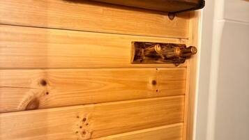 A wooden wall with a towel rack and a shelf.