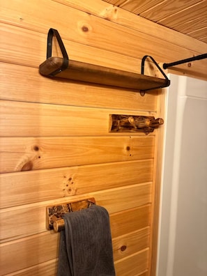 Un mur en bois avec un porte-serviettes et une étagère.