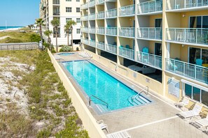 Ein Hotel mit Pool, mehreren Balkonen und Blick auf den Strand.