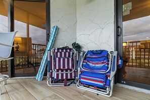 Ein Zimmer mit Holzboden, einem Sessel und zwei Gepäckwagen mit gestreiftem Gepäck.