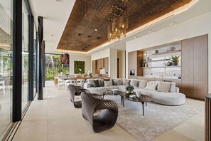A spacious living area with a modern sofa set, a dining area with a wooden table, and a kitchen with marble countertops. - Exclusive 6BR Ocean-View Villa with detached apartment - Peninsula Papagayo (Peninsula Papagayo, Nacascolo)