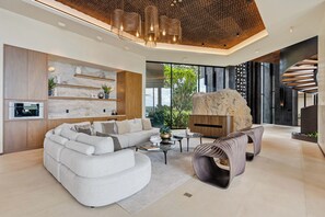 A modern living room with a sectional sofa, a coffee table, and a unique rock feature. - Exclusive 6BR Ocean-View Villa with detached apartment - Peninsula Papagayo (Peninsula Papagayo, Nacascolo)