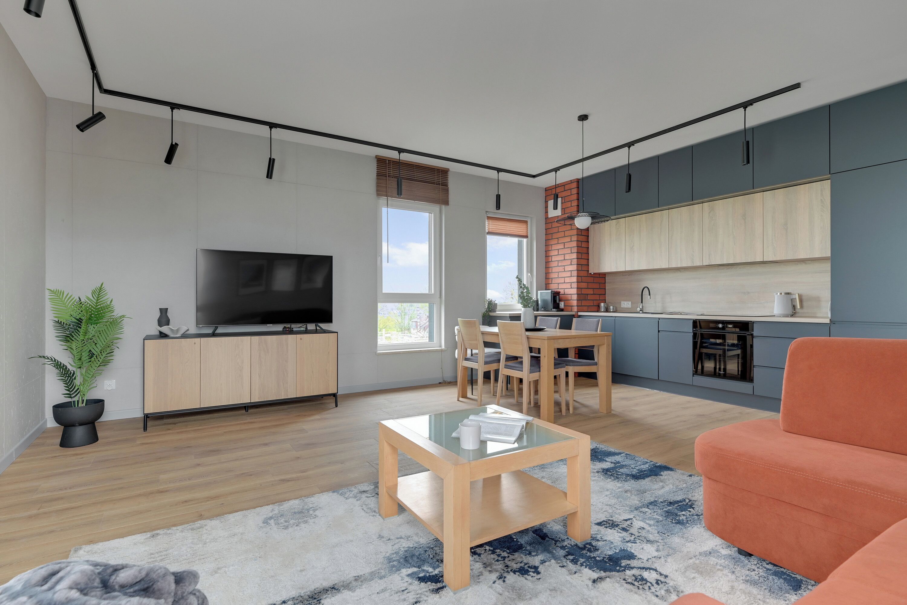 A modern living room with a flat-screen TV, a coffee table, and a sofa.