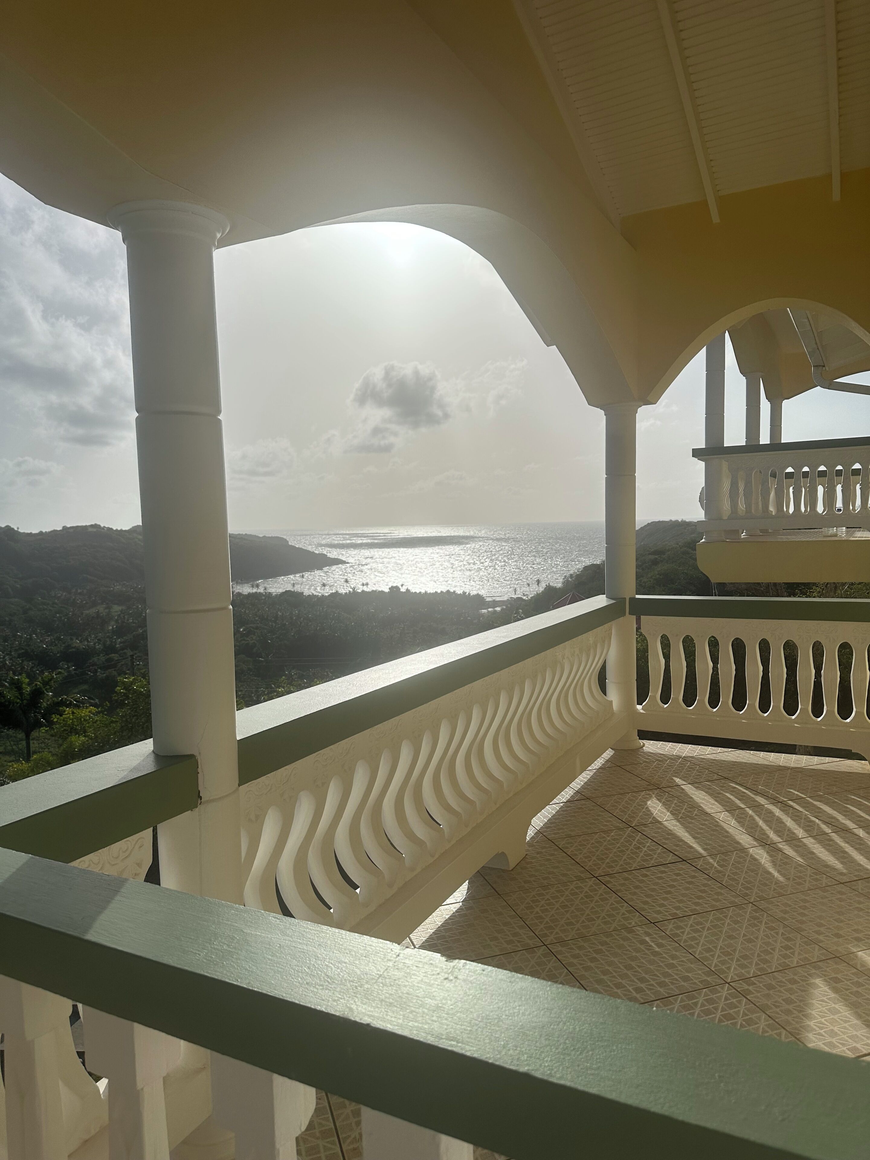Ein Balkon mit Blick auf das Meer und die Hügel.