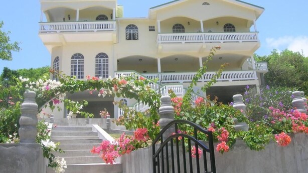 Um edifício com vários andares, varandas e uma escadaria que leva à entrada.