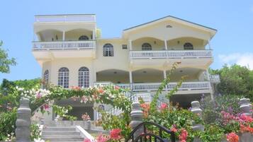 A multi-story building with balconies and a staircase leading to the entrance.