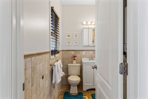 A bathroom with a toilet, sink, and a towel rack.