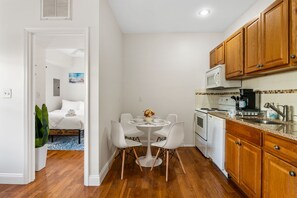 A compact kitchen with wooden cabinets, a microwave, and a coffee maker.