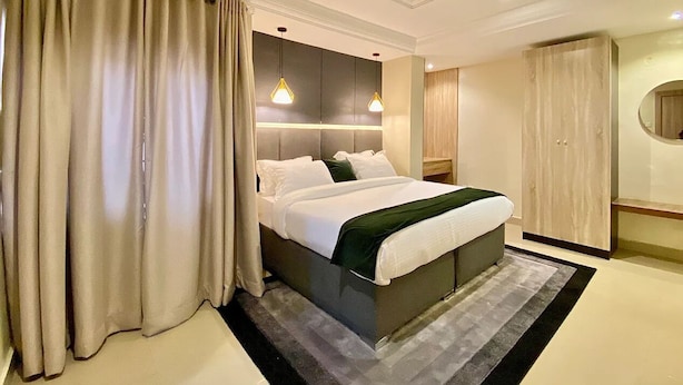 Ett modernt hotellrum med en stor säng, en garderob och en spegel.