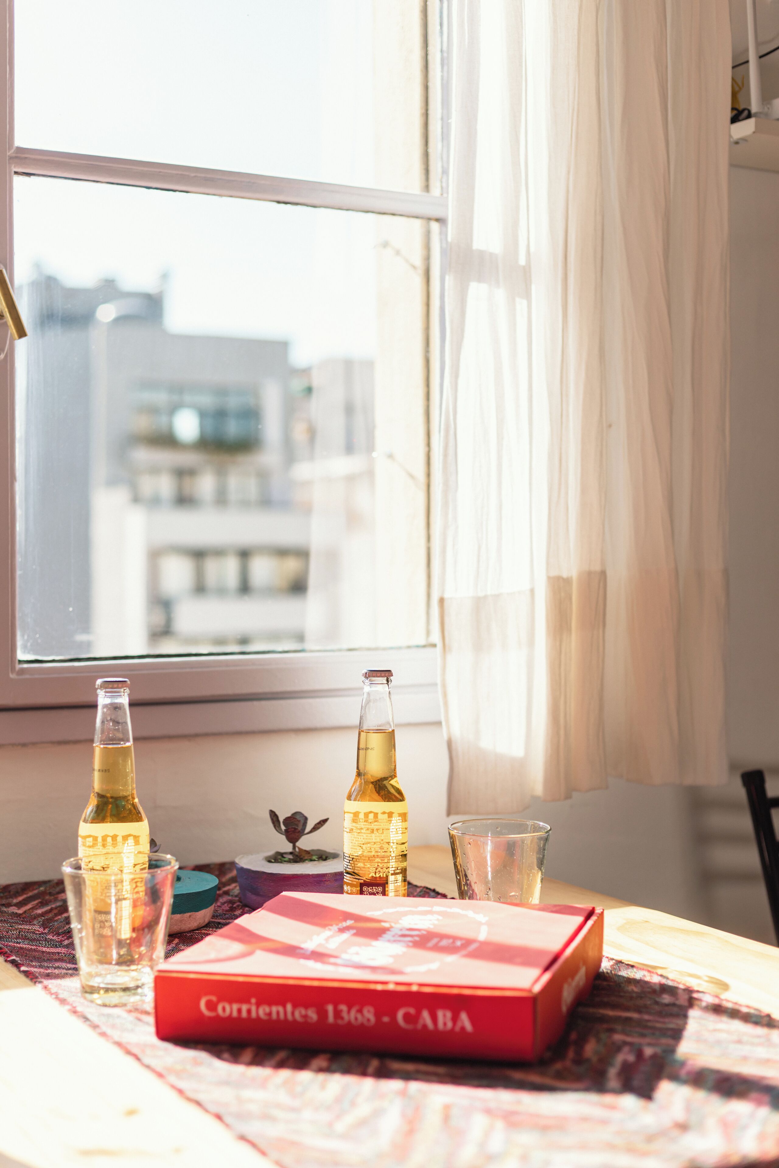 A table with a bottle, a glass, a book, and a box.