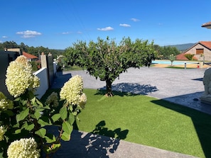 A courtyard with artificial grass, a tree, and a statue.
